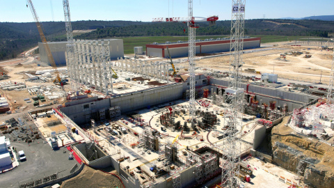 Imagen actual de las obras del ITER tomada por un drone desde 60 metros de altura. La estructura circular corresponde al reactor tokamak. Las columnas metálicas indican el edificio de montaje. Al fondo, el primer edificio terminado, destina