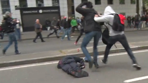 Un policía belga, inconsciente tras recibir un golpe en la cabeza durante la manifestación en Bruselas.