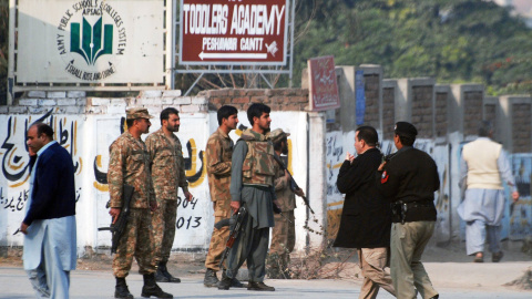 Fuerzas de seguridad paquistaníes toman posiciones en la entrada de la Escuela Pública Militar de Peshawar, tras el ataque talibán. REUTERS/Khuram Parvez