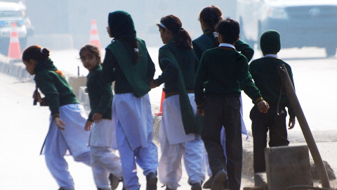 Unos niños cruzan la calle huyendo de la Escuela Militar, que ha sido atacada por los talibán en la ciudad paquistaní de Peshwar. REUTERS/Khuram Parvez