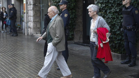 Jordi Pujol y su esposa, Marta Ferrusola, salen de su domicilio durante el registro de la UDEF. EFE/Quique García