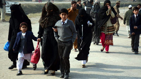 Varios alumnos acompañan a sus madres tras ser rescatados por las Fuerzas de Seguridad durante el ataque talibán contra un colegio gestionado por el Ejército en Peshawar (Pakistán). EFE/Bilawal Arbab