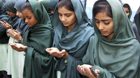 Varias alumnas rezan por los estudiantes asesinados alumnos en el ataque talibán contra un colegio gestionado por el Ejército en Peshawar, en una ceremonia celebrada en su escuela en Hyderabad (Pakistán). EFE/Nadeem Khawer