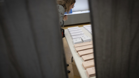 Un miembro de una mesa electoral del colegio CEIP Ciudad de Roma proceden al recuento de votos, tras el cierre de su centro electoral este domingo en Madrid.