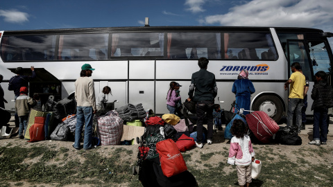 Refugiados sirios junto a un autobúis durante el desaolo policial del campo de Idomeni, en la frontera de Grecia con Macedonia. REUTERS/Yannis Kolesidis