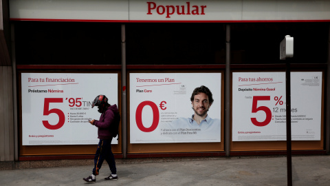 Un hombre con un casco de motorista pasa por delante de una sucursal del Banco Popular eb Madrid. REUTERS/Susana Vera