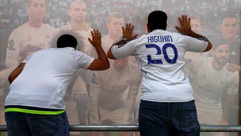 Dos aficionados posan para una foto con un poster de los jugadores del Real Madrid en Milán, donde el sábado se juega la fina de la Champions League. REUTERS/Pawel Kopczynski