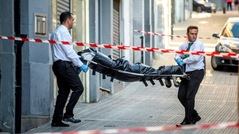 Operarios de los servicios funerarios retiran el cuerpo de la mujer asesinada por su marido en Bilbao. EFE/JAVIER ZORRILLA