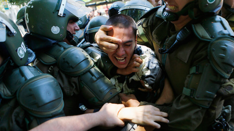 Un estudiante es detenido durante una manifestación cerca del Ministerio de Educación en Santiago de Chile contra el aumento en el precio de las tasas. /IVAN ALVARADO