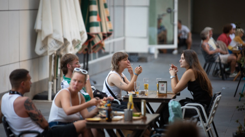 Varias personas sentadas en terrazas en la plaza dels Àngels del Raval, a 4 de agosto de 2022, en Barcelona.