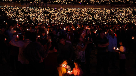 Cristianos indonesios sostienen velas durante una misa de navidad masiva en el estado Gelora Bung Karno, en Jakarta (Indonesia). /BEAWIHARTA (REUTERS)