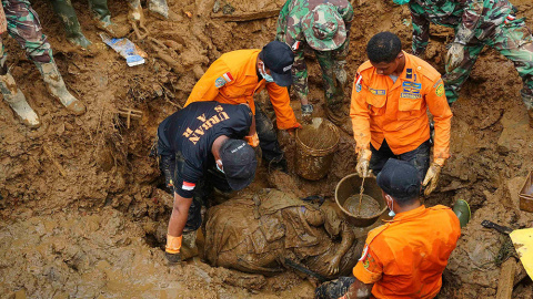 Soldados y miembros de los equipos de rescate recuperan los cadáveres de una madre y su hijo tras un deslizamiento de tierra en la aldea de Sampang en Banjarnegara. /ADHAD ZAKARIA (REUTERS)