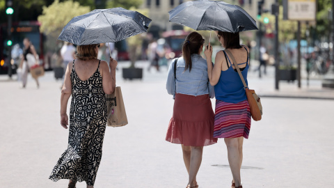 Tres mujeres se protegen del calor con unos paraguas en Valéncia a 4 de julio de 2023.