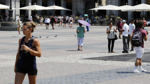 12/07/2022-Personas se protegen del calor el 12 de julio en una jornada marcada por las altas temperaturas, en la Plaza de Mayor de Madrid