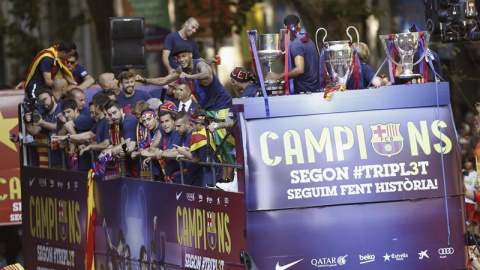 Los jugadores del FC Barcelona recorren en autobús las calles de Barcelona. /EFE