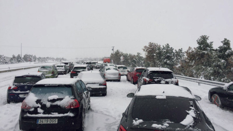 Fotografía facilitada por un conductor retenido en la A-6, a la altura del Km 75, en sentido Madrid. Familias atrapadas en sus coches por la nevada en la AP6 han pasado la noche en sus coches a la espera de que las máquinas quitanieve pueda