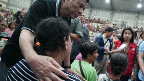 El presidente de Filipinas, Rodrigo Duterte, abraza a una mujer evacuada por un tifón en Filipinas. (EFE)