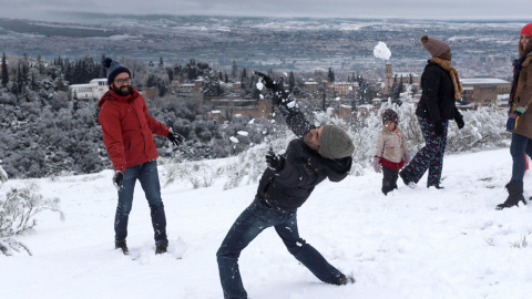 Varias personas juegan con la nieve con la Alhambra de Granada de fondo, que ha recibido una intensa nevada y deja estampas invernales en la provincia y en la Capital Granadina.EFE/Miguel Ángel Molina