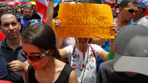 Una mujer sostiene una pancarta durante las protestas en San Juan / REUTERS