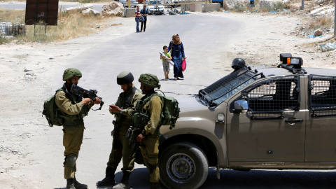 Soldados israelíes vigilan la entrada a la ciudad palestina de Yatta. REUTERS/Mussa Qawasma