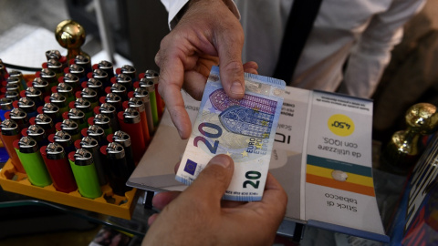 Un hombre paga con un billete de 20 euros en una tienda en Milán. REUTERS/Flavio Lo Scalzo