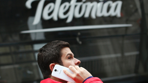 Un hombre habla por su móvil, delante de la sede de Telefónica en la madrileña Gran Vía. REUTERS