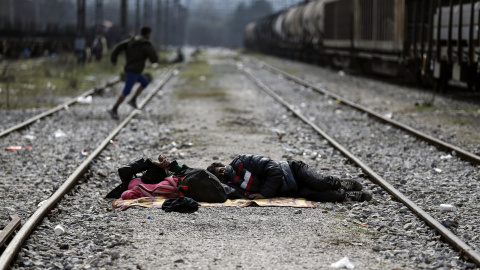 Dos refugiados duermen en las vías del tren en un campamento improvisado en la frontera entre Grecia y Macedonia, cerca de la localidad de Idomeni. REUTERS/Alkis Konstantinidis