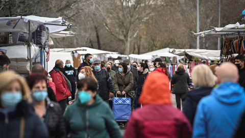 Varias personas compran en el mercadillo de Alcalá de Henares después de que la Comunidad de Madrid levantase este lunes las restricciones de movilidad por el coronavirus.