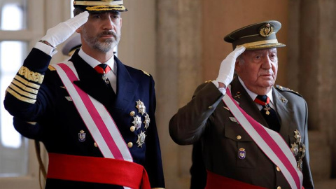 El Rey Felipe VI y el Rey emérito Juan Carlos, escuchan el himno nacional, a su llegada a la celebración hoy de la Pascua Militar en el Palacio Real. / EFE