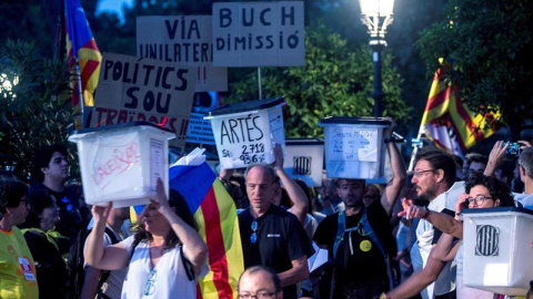 01/10/2018.- Varios manifestantes portan pancartas y urnas utilizadas el año pasado en el referéndum unilateral de independencia, hoy en Barcelona durante la marcha soberanista "Recuperemos el 1-O", que reivindica el cumplimiento del "manda