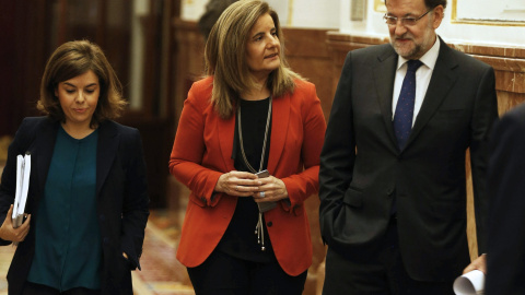 Mariano Rajoy con la ministra de Empleo, Fátima Bañez, y la vicepresidenta Soraya Sáenz de Santamaría, en los pasillos del Congreso de los Diputados. EFE