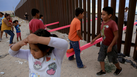 Los niños mexicanos se divierten en la frontera mientras juegan con niños norteamericanos, situados al otro lado de la valla. LUIS TORRES (AFP).