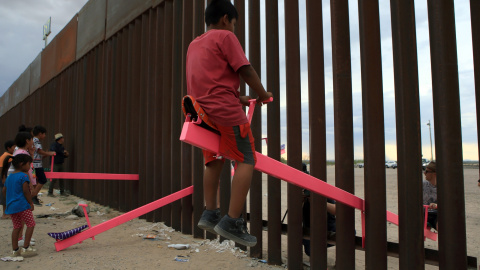 Familias americanas y mexicanas juegan con un balancín en mitad de la valla fronteriza que divide a los dos países LUIS TORRES (AFP).