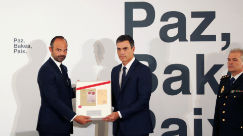 El presidente del Gobierno, Pedro Sanchez, y el primer ministro francés, Edouard Philippe, posan con una copia de los documentos confiscados a ETA que el Ejecutivo galo ha entregado al español. REUTERS/Susana Vera