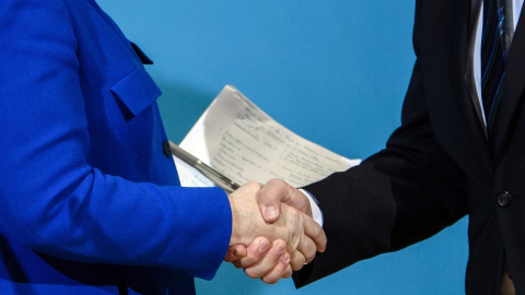 La canciller alemana y líder de la Unión Cristianodemócrata (CDU), Angela Merkel, y el líder del Partido Socialdemócrata (SPD), Martin Schulz, se saludan después de una rueda de prensa tras las negociaciones para formación de Gobierno, en B