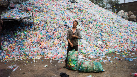 Un trabajador recoge botellas de plástico en una de las plantas de reciclaje de China. FRED DUFOUR / AFP