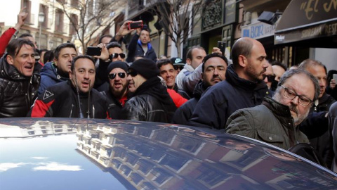 El concejal de Salud, Seguridad y Emergencias de Madrid, Javier Barbero (d), a la salida hoy de las dependencias municipales, se introduce en un coche mientras es increpado por los asistentes a una concentración de policías municipales, en 