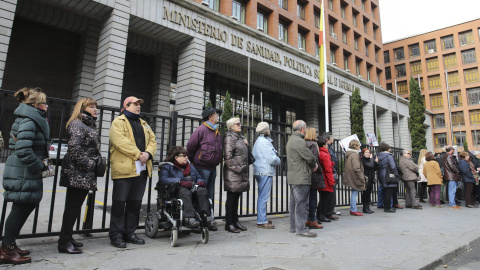 Varias personas participan en una cadena humana, organizada por la Plataforma de Afectados por la Hepatitis C, rodeando el Ministerio de Sanidad para exigir tratamientos para la enfermedad.- EFE/Ballesteros