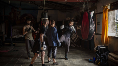 Un grupo de jóvenes entrena Boxeo en una de las naves del pueblo.