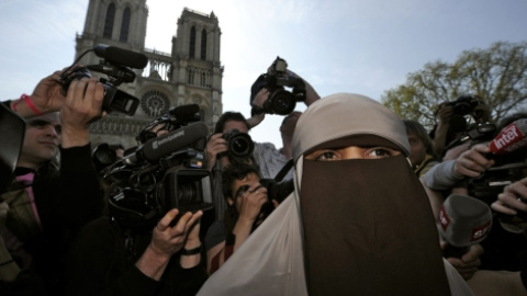 La primera mujer detenida en Francia por llevar burka, rodeada de periodistas. | Reuters