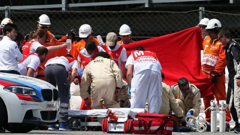 El piloto español de Moto2 Luis Salom, del equipo SAG Team, es atendido por los servicios sanitarios tras sufrir un accidente en la segunda sesión de entrenamientos libres del Gran Premio de Catalunya de motociclismo. EFE/Toni Albir