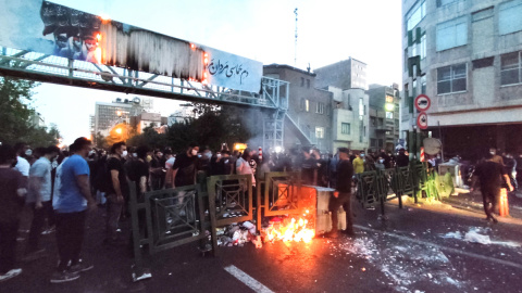 La gente se enfrenta a la policía durante una protesta tras la muerte de Mahsa Amini, en Teherán, Irán.