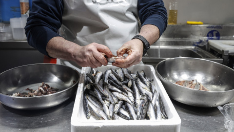 Un vendedor limpia pescado en un puesto de pescado en el Mercado Central de Valencia, a 24 de marzo de 2022, en Valencia, Comunidad Valenciana, (España).