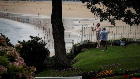 Una pareja se fotografía junto a la playa de La Concha de San Sebastián. (JAVIER ETXEZARRETA | EFE)