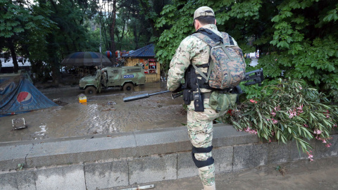 Un policía fuertemente armado vigila cerca de un parque en Tblisi después de la fuga de varios animales del zoo de la capital de Georgia por  las fuertes inundaciones. EFE/EPA/BESO GULASHVILI