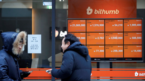 Dos personas conversan junto a un escaparate en Seul, con un monitor que muestra la cotización de varias criptodivisas. REUTERS/Kim Hong-Ji