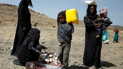 Yemeníes reciben raciones de comida de la organización Mona Relief Yemen este lunes en Saná.