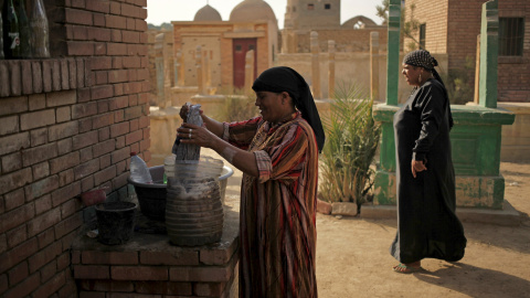 Una mujer hace la colada frente a su pequeña vivienda en la Ciudad de los Muertos, la necrópolis de El Cairo en la que residen miles de personas desde hace cientos de años. REUTERS/Asmaa Waguih