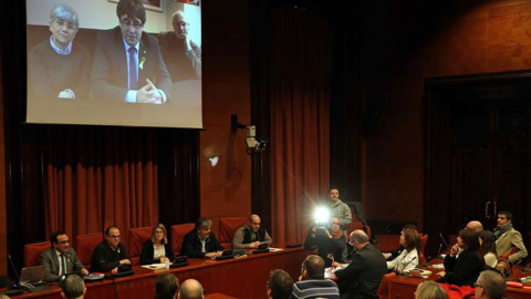 Los diputados electos Carles Puigdemont (c), Clara Pontasí (i) y Lluís Puig (d), participaron telemáticamente desde Bruselas en la reunión celebrada el martes en el Parlament por el grupo parlamentario de Junts per Catalunya. EFE/Toni Albir