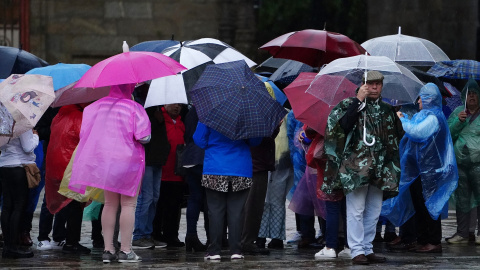 Un grupo de personas con paraguas durante el paso de la borrasca ‘Aline’, a 19 de octubre de 2023, en Santiago de Compostela, A Coruña, Galicia